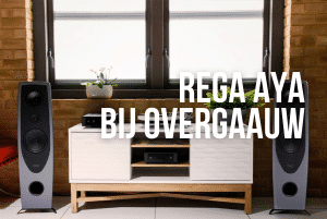 Rega Aya speakers in het zilver met zwarte accenten met een witte kast ertussen bij Overgaauw